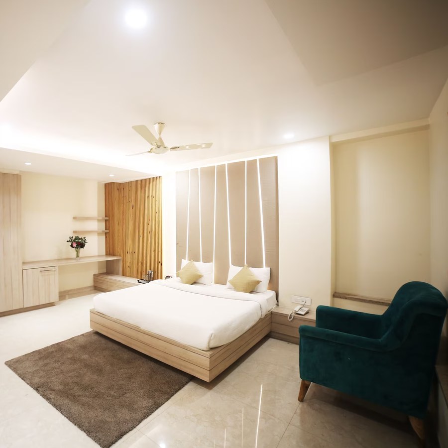 Guest room with armchair and desk at Hotel Avantika, Bhopal